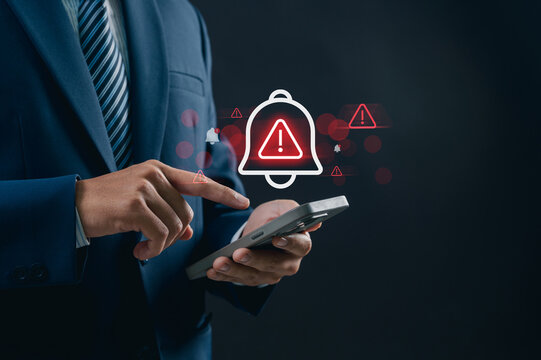 Corporate man handling emergency alert notification on mobile phone, concept of warning message, cyber threat monitoring, digital security breach, urgent system error, and risk management