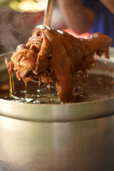 Delicious stewed hot pork leg for serve. Stewed leg pork style chinese food on steamed pot. Pork stewed in the gravy, knuckle of pork and egg boiled in the gravy.