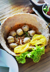 Delicious Tom Yum Soup with pork, Noodles. Traditional street food-Thai flavorful meal.