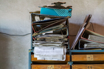 ruined shelf full of chaotically arranged binders, folders and documents. The furniture and papers...