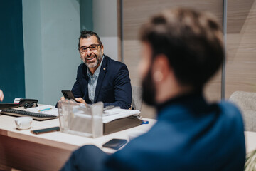 Two colleagues sit together during a professional discussion, focusing on collaborative work in an...