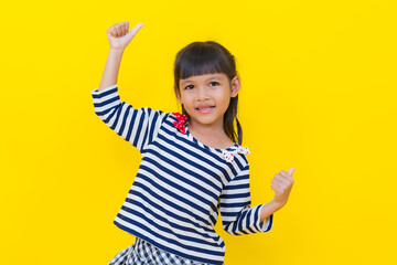 Happy girl showing thumbs up on yellow background