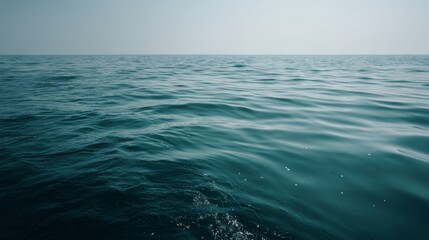 This serene seascape features a deep turquoise ocean with gentle ripples under soft sunlight, creating a calming atmosphere perfect for relaxation and contemplation