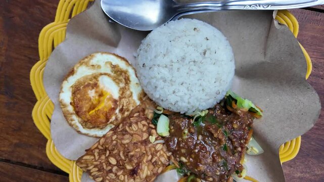 Sego Pecel is a traditional dish from Java, Indonesia, consisting of boiled vegetables, peanut sauce, and side dishes.