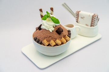 Chocolate bingsu dessert with whipped cream, brownies, and wafer rolls on a white plate, Sweet Treat