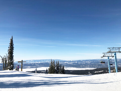 Ski lift at Brundage Mountain ski resort and panoramic views of snow-covered mountains. - Powered by Adobe