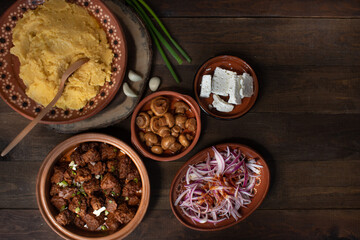 Traditional Eastern European corn mush (mamaliga, polenta, banosh, balmes) served with side dishes and vegan seitan