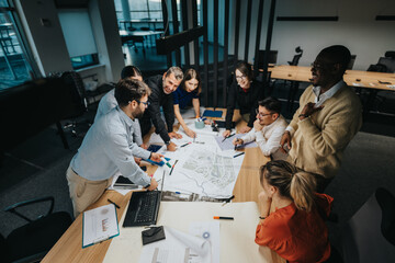 A diverse group of business people gather around a conference table, actively discussing and...