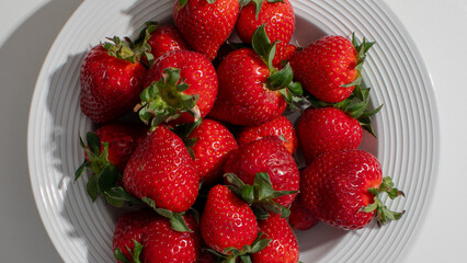 Fresh strawberries in a white bowl, symbolizing summer harvest and healthy eating, perfect for summer solstice celebrations