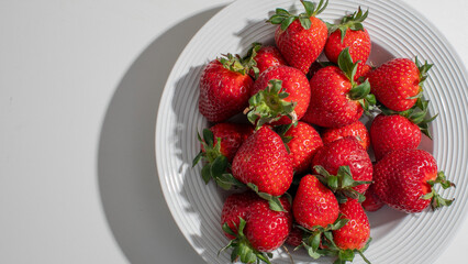 Fresh strawberries on a white plate, symbolizing summer harvest, healthy eating, perfect for Independence Day or family picnics