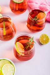 Delicious Negroni cocktail with lime and rosemary in glasses on the table vertical view