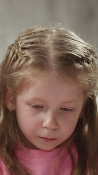 Smiling African-American teacher helps cute little girl do English language homework at private tuition with native speaker closeup slow motion