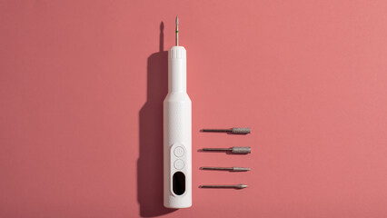 Sleek electronic manicure set with various attachments on pink background, personal care, grooming essentials, Mother's Day gift idea