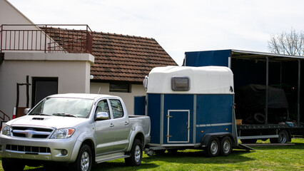 Silver pickup truck towing a blue horse trailer on a sunny day, road trip adventure, outdoor exploration concept © fotoworld