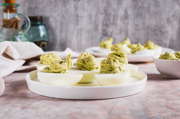 Eggs stuffed with avocado and yolk mixture on a plate on a table