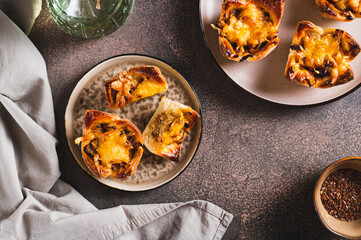 Mini tartlets with caramelized onions and cheese on a plate on a table top view