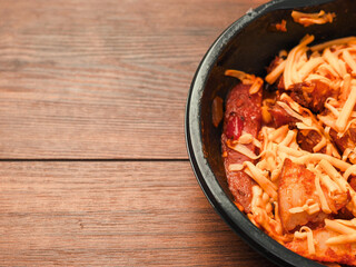 Ready made dish with wedges, garlic sauce and cheese in plastic tray on wooden table surface. Fast food made of high quality products ingredients. Lunch for cooking in microwave. Copy paste space.