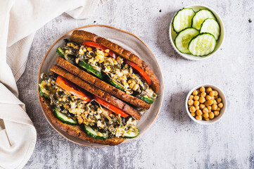 Vegetarian sandwich with seaweed, chickpeas, cucumber and tomato on grain bread top view