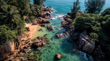 Aerial view of secluded tropical beach with clear turquoise water, rocky coastline, and lush green vegetation. Sunlight glistens on the surface.