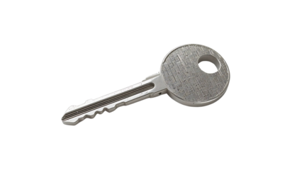 Isolated silver key with intricate design on black background in a close up studio shot view .