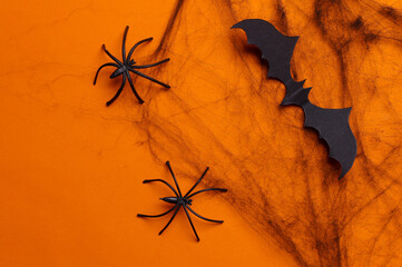 Black decorative web with spiders and bat on orange background. Halloween decor