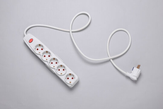 White electric extension cord with power button on gray background