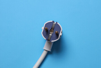 Electric plug with cable on blue background