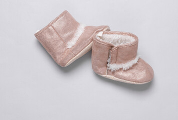 Baby's warm boots on gray background