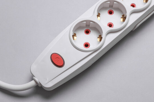 White electric extension cord with power button on gray background