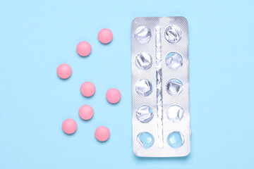 Pink tablets with blister on blue background