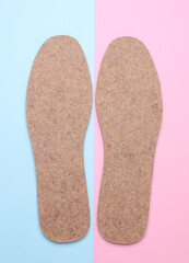 Pair of warm felt insoles on a white background