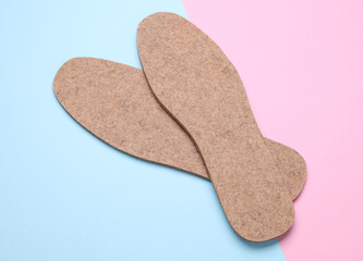 Pair of warm felt insoles on a white background