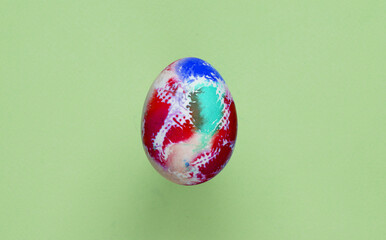 Multicolored Easter egg on a green background