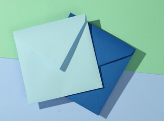 Two blue square envelopes on a pastel background