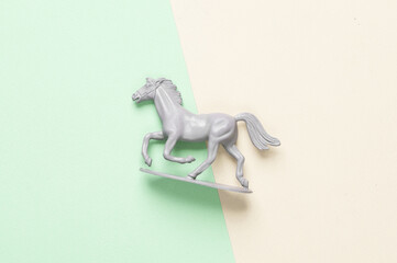 Plastic running horse on pastel background