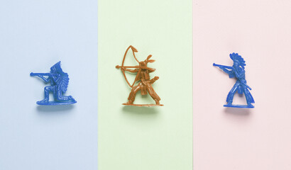 Plastic American Indian soldiers on pastel background. Wild west, western. Minimalism