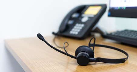 VOIP headset for callcenter on desk at customer service office. Communication support for sale support and telemaketing Helpdeskac