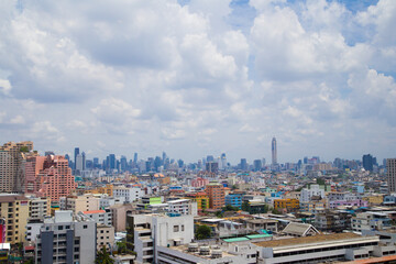 Fototapeta premium Cityscape. Suburban Asian city view of low rises buildings and clear blue sky with clouds in Bangkok, Thailand