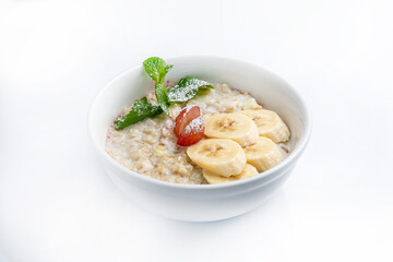Oatmeal porridge with banana and grape in bowl on white background