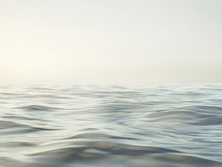 This image portrays a serene ocean scene, with vast blue waters stretching into the horizon under an overcast sky. The calm surface of the water reflects the light softly, creating a peaceful and