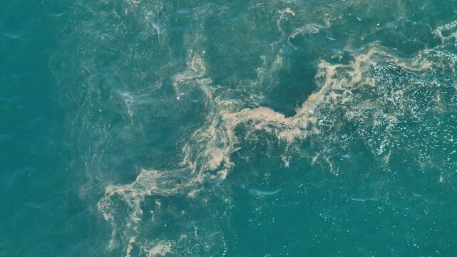 The image from above highlights the challenge of ocean cleanups, with large swaths of plastic and trash disrupting the beauty of marine waters, urging immediate action.
