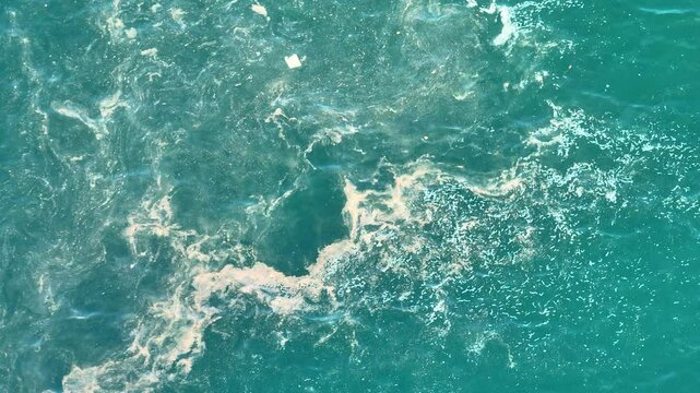 This drone perspective reveals water tainted with trash, highlighting the harmful effects of marine litter on aquatic ecosystems and biodiversity.
