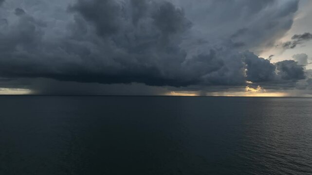A breathtaking aerial view captures the massive storm above the ocean, with swirling clouds and rain, portraying the immense power and unpredictability of nature.
