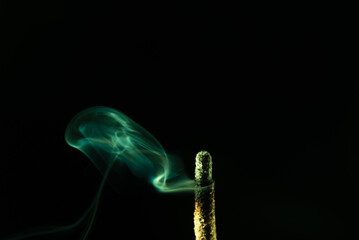 Abstract swirling incense smoke in soft green tones.