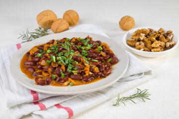 Red beans in tomato sauce with green onions and walnuts. Lenten vegetarian food
