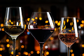 Wines in glasses set. Red, white, rose wine on dark background with bottles. Bar, shop, tasting or...