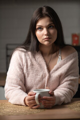 Portrait of a young beautiful dark-haired girl in the home kitchen.