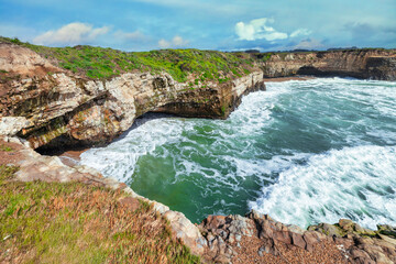 Coastal cliffs along California's Highway 1 in California. Rugged ocean rocks, crashing waves, and...