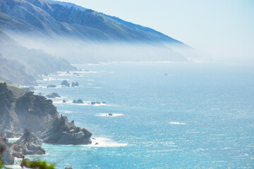 Stunning coastal landscape along California's Highway 1, featuring rugged rocky formations, and the vast blue ocean. A breathtaking natural scene showcasing the raw beauty of the Pacific coastline