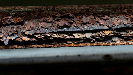 
Heavily rusted and corroded metal surface. Layers of peeling. Reddish brown rust are prominent....
